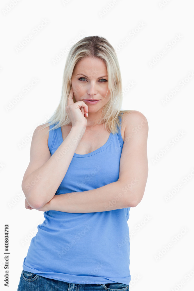 Thoughtful blonde woman placing a finger on her cheek Thoughtful blonde woman placing a finger on her cheek