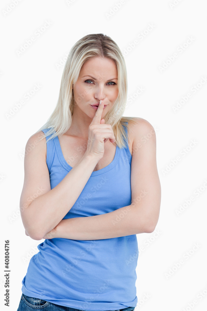 Blonde woman telling to be quiet with her arms crossed Blonde woman telling to be quiet with her arms crossed