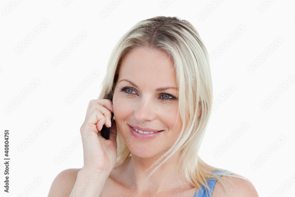 Smiling blonde woman using her cellphone Smiling blonde woman using her cellphone