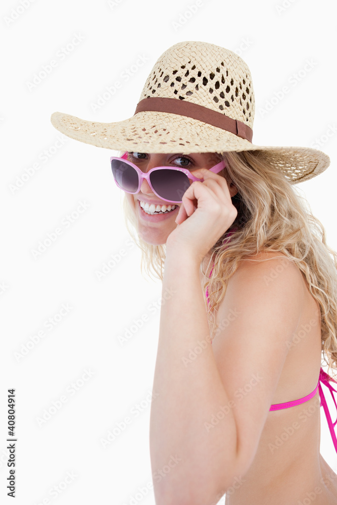 Smiling teenager in a swimsuit looking over her sunglasses Smiling teenager in a swimsuit looking over her sunglasses
