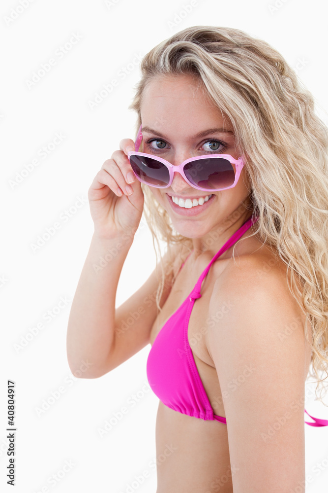 Smiling attractive teenager looking over her sunglasses Smiling attractive teenager looking over her sunglasses