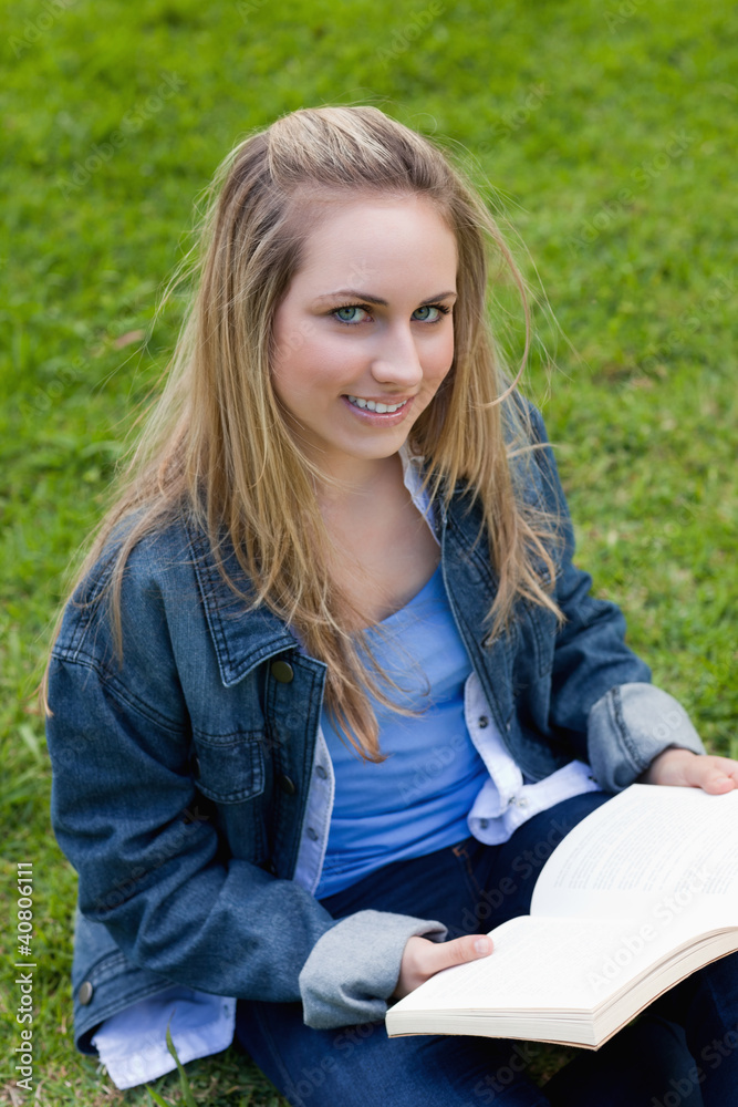 Young smiling woman looking straight at the camera while holding Young smiling woman looking straight at the camera while holding