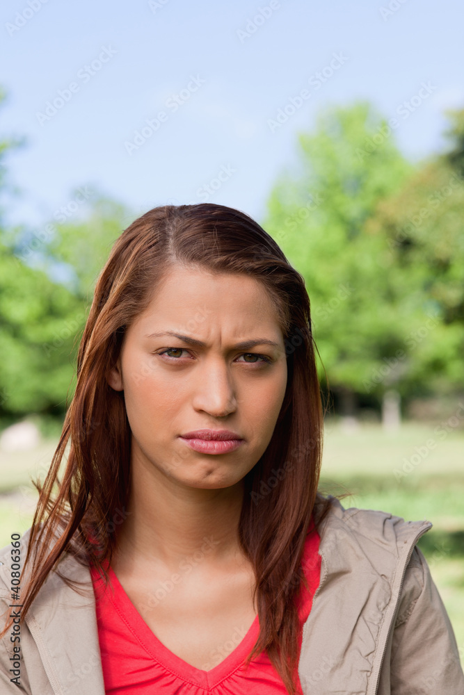 Woman looking ahead of her with a serious expression on her face Woman looking ahead of her with a serious expression on her face