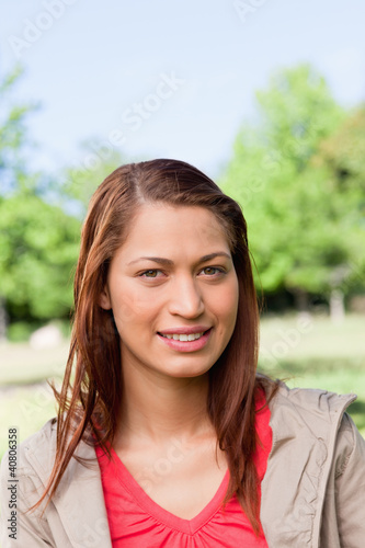 Young woman smiling as she looks into the distance while in a br