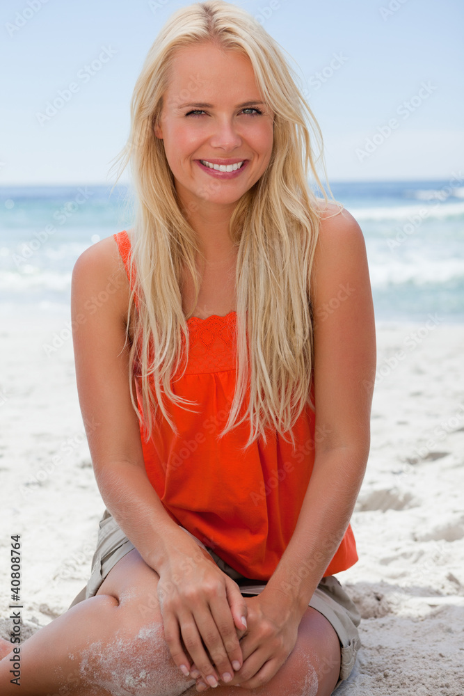 Young smiling blonde woman sitting on the beach Young smiling blonde woman sitting on the beach