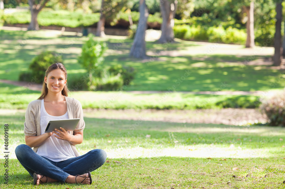 Woman in the park using her tablet computer Woman in the park using her tablet computer