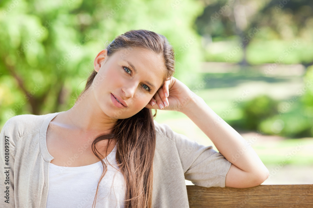 Thoughtful woman sitting on a park bench Thoughtful woman sitting on a park bench