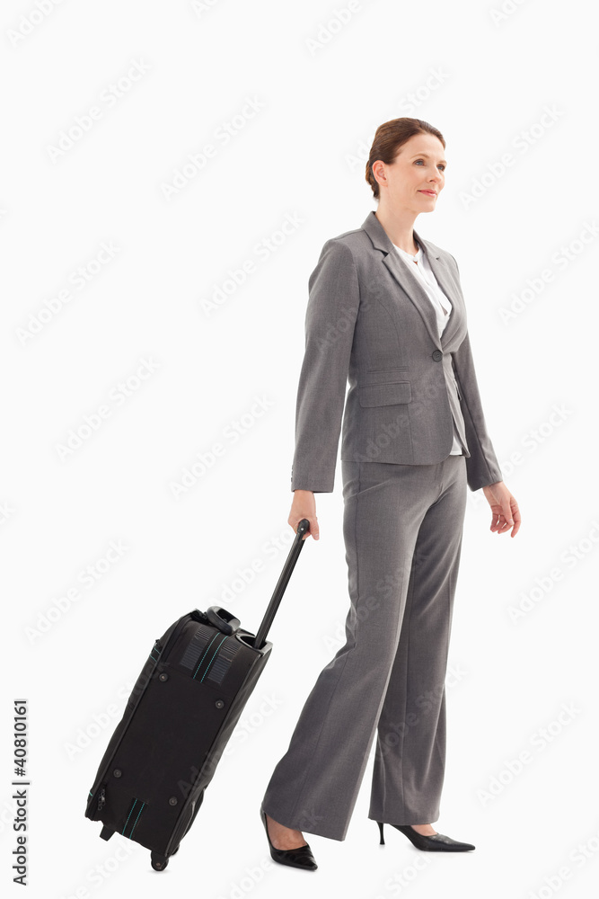 Smiling businesswoman with suitcase walking Smiling businesswoman with suitcase walking
