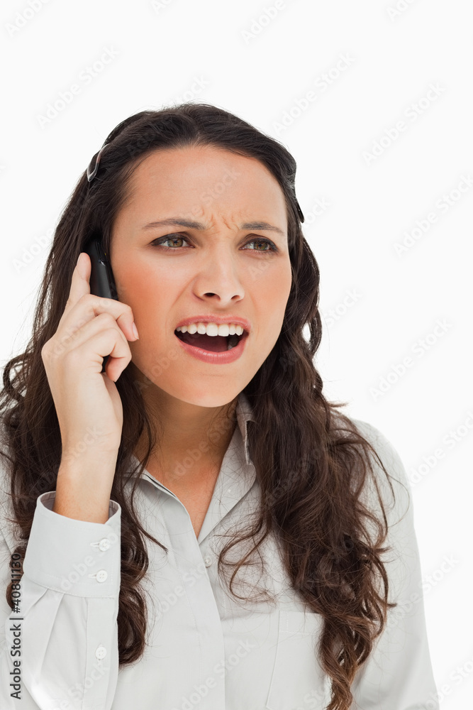 Portrait of a brunette grimacing while phoning Portrait of a brunette grimacing while phoning