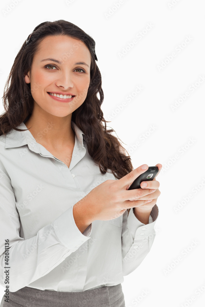 Portrait of a brunette smiling while using her mobile Portrait of a brunette smiling while using her mobile