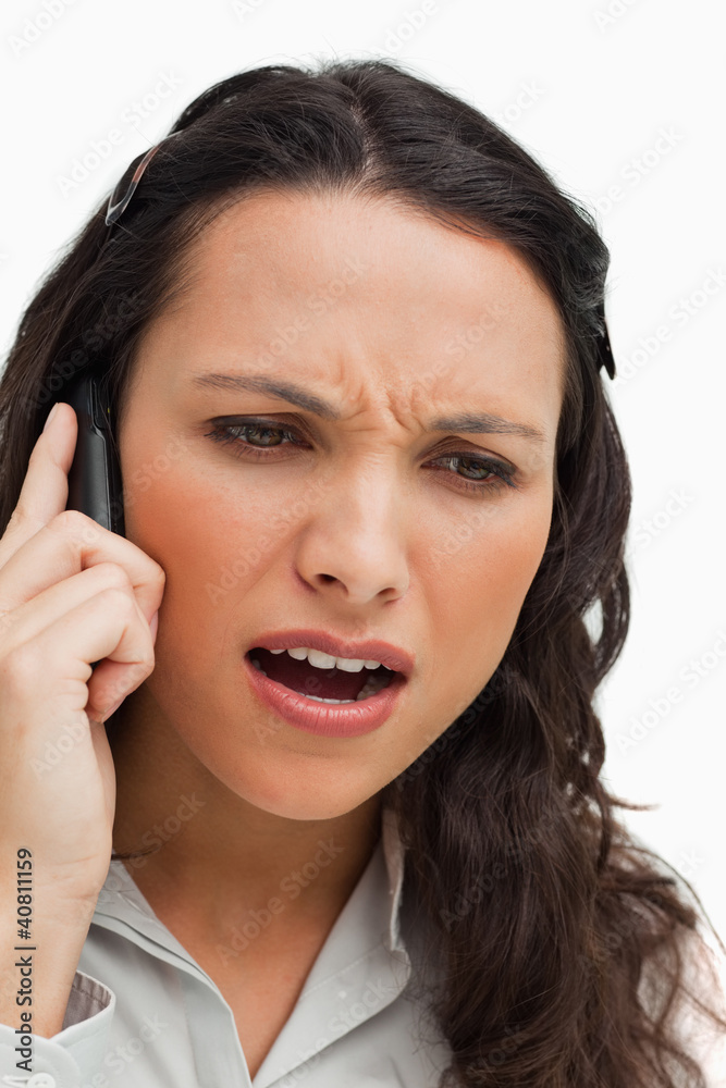 Close-up of a brunette frowning while phoning Close-up of a brunette frowning while phoning