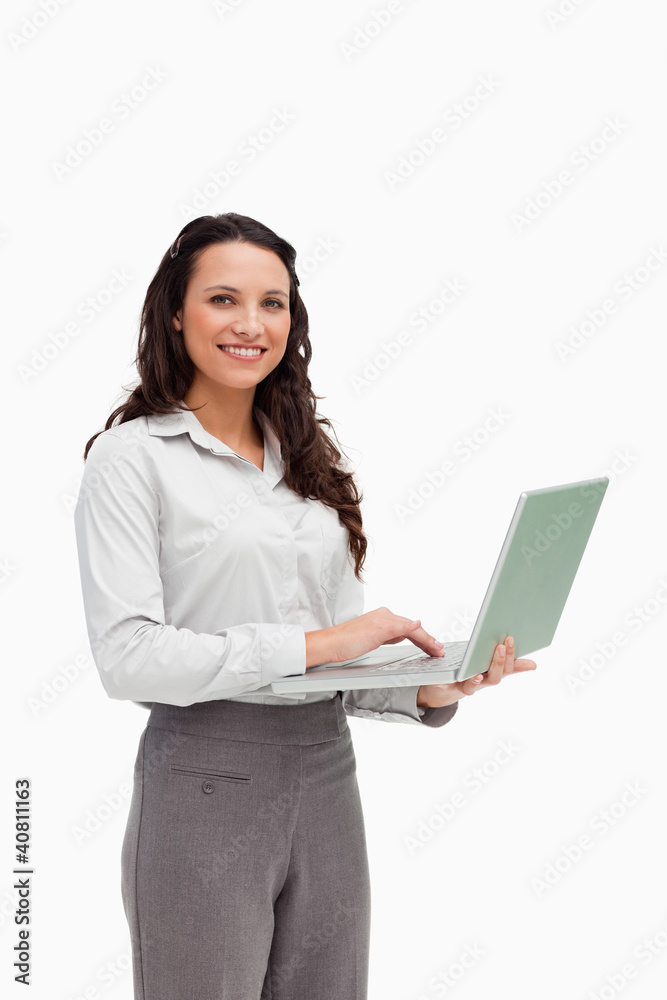 Portrait of a brunette standing while using a laptop Portrait of a brunette standing while using a laptop