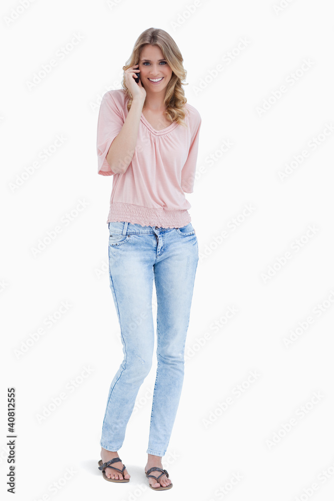 Full length shot of a smiling woman talking on her mobile phone Full length shot of a smiling woman talking on her mobile phone