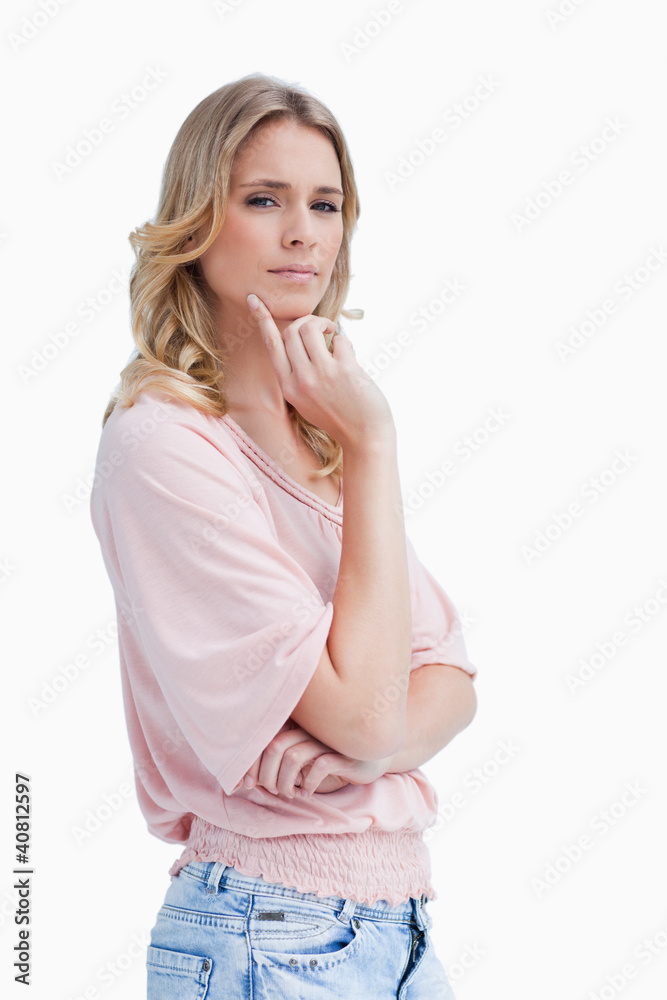 A woman with her hand held up to her face is thinking