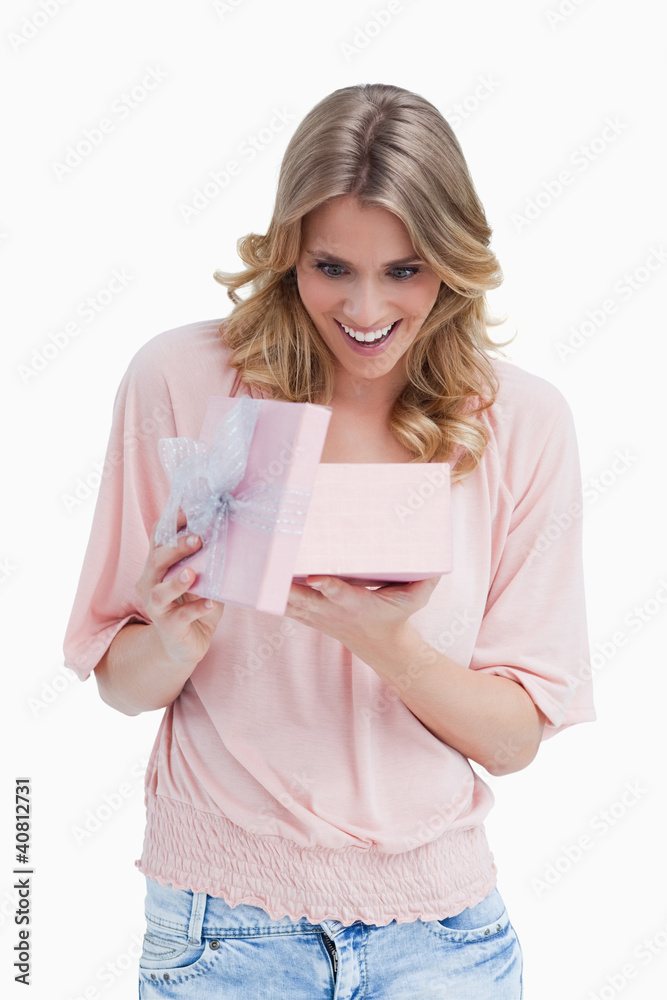 Surprised young woman looking at her present Surprised young woman looking at her present