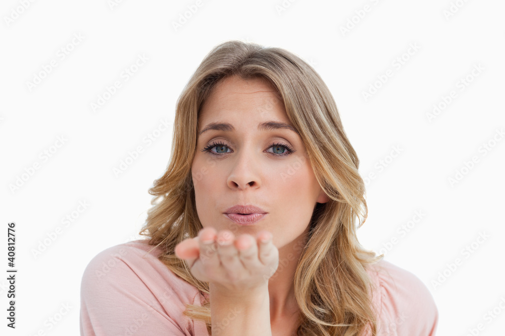 Young blonde woman blowing while sending an air kiss Young blonde woman blowing while sending an air kiss