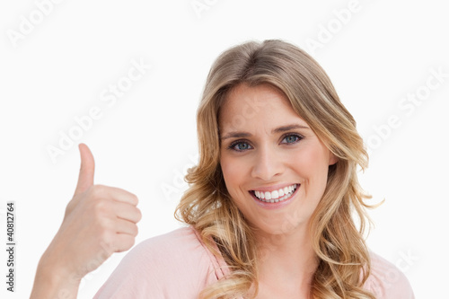 Young smiling woman placing her thumbs up