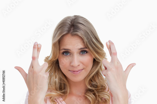 Smiling young woman crossing her fingers