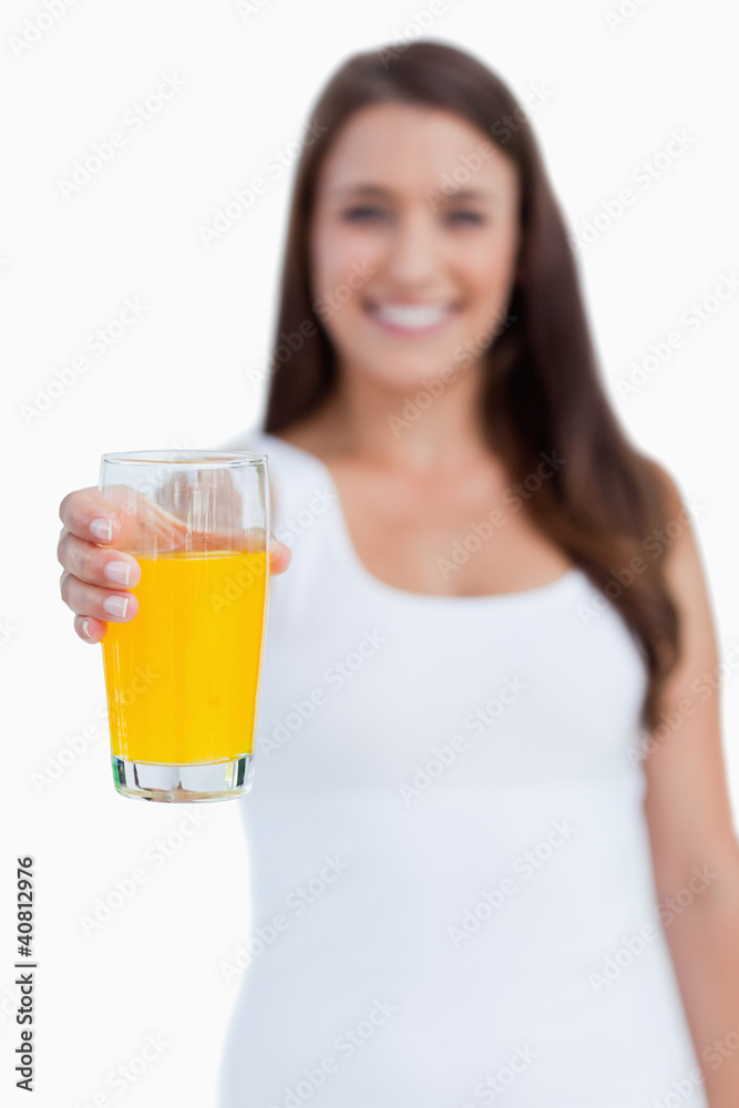 Glass of orange juice being held by a young woman Glass of orange juice being held by a young woman