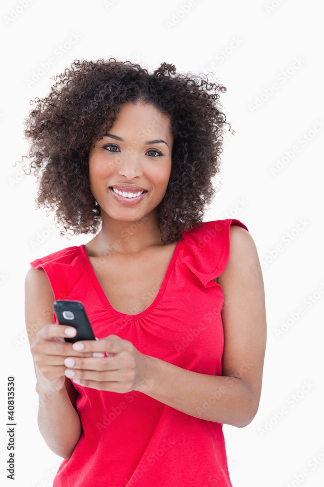Smiling young woman holding her mobile phone Smiling young woman holding her mobile phone