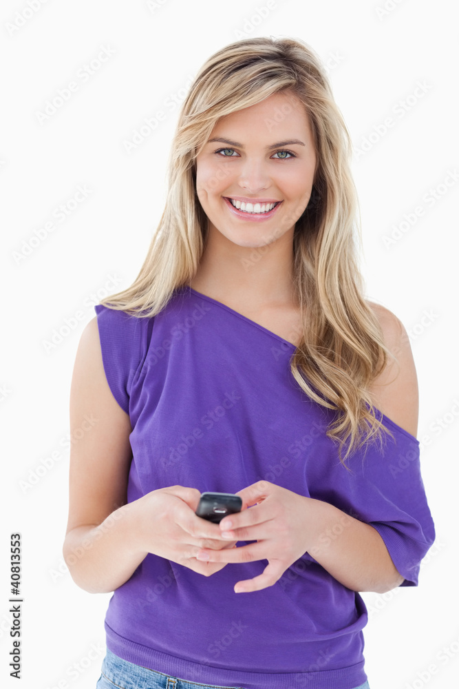 Smiling blonde woman looking at the camera while holding her mob Smiling blonde woman looking at the camera while holding her mob