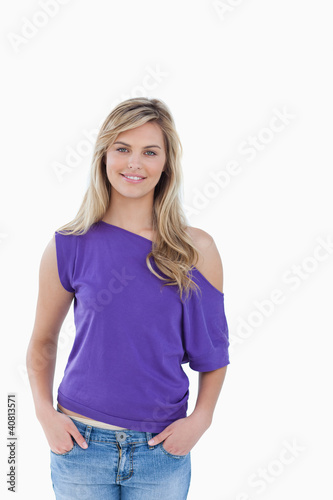 Smiling blonde woman placing her hands in her pockets