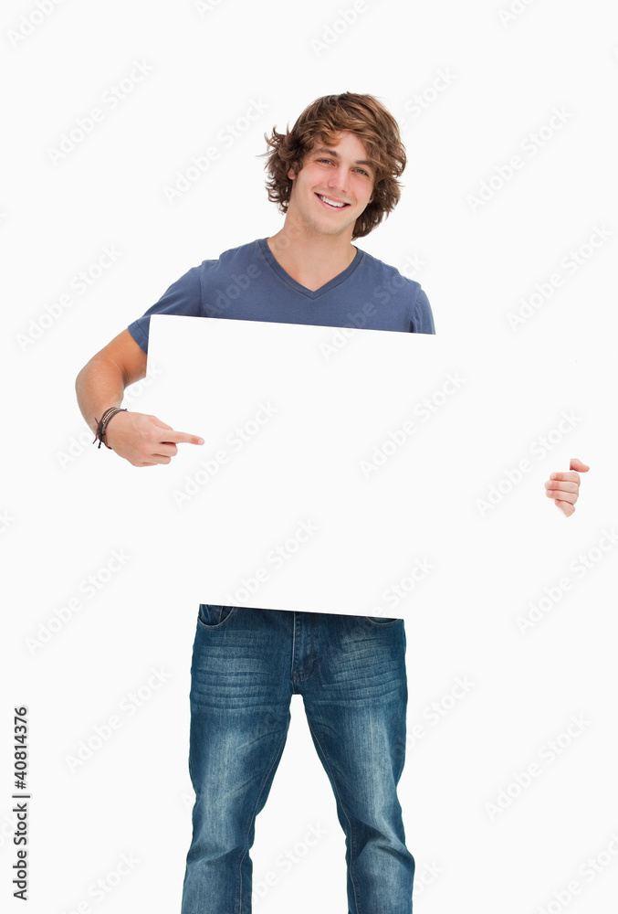 Male student posing while holding and pointing a white board Male student posing while holding and pointing a white board