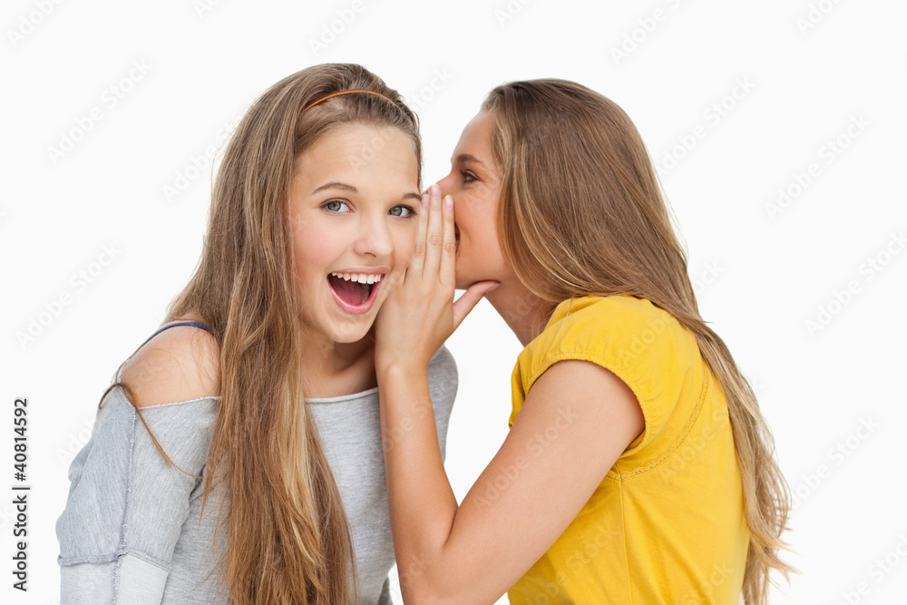 Blonde student whispering to her friend Blonde student whispering to her friend