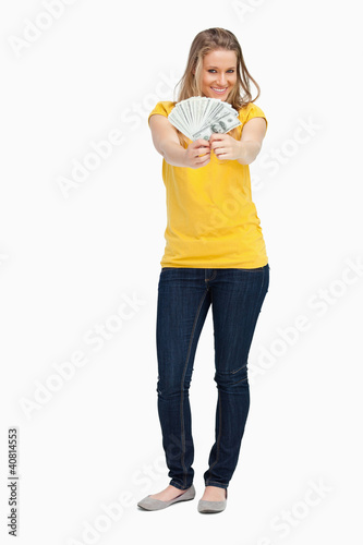 Blonde woman smiling while showing a lot of dollars