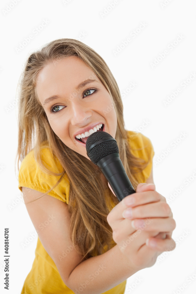 Fisheye view of blonde girl singing with a microphone Fisheye view of blonde girl singing with a microphone