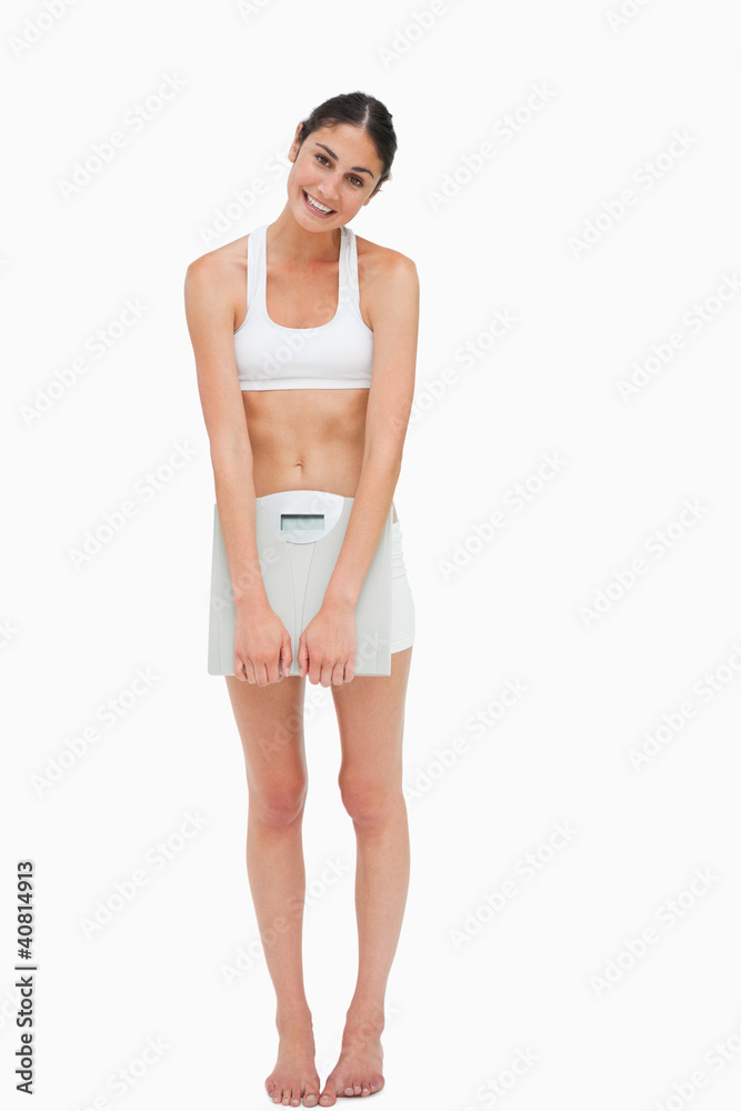 Slim young woman holding a scales Slim young woman holding a scales
