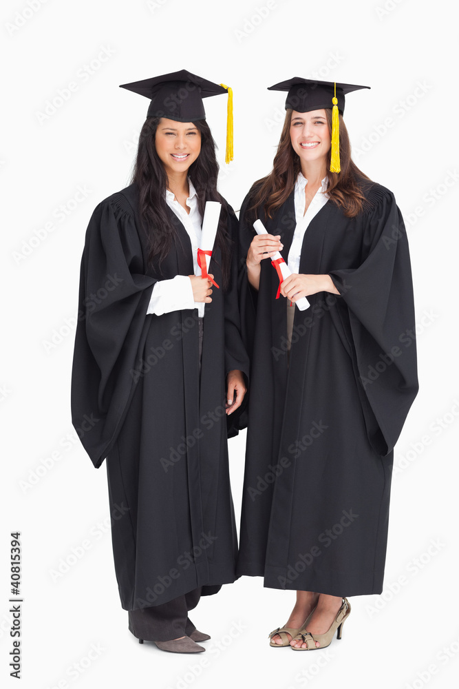 Full length shot of two women graduating