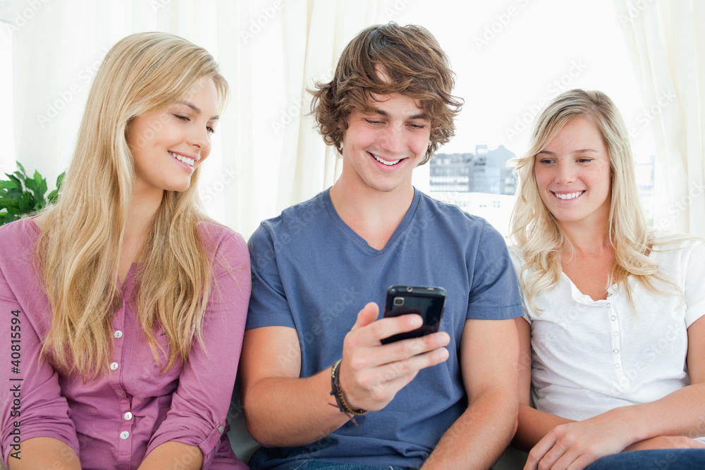 Three friends sitting and looking into the phone Three friends sitting and looking into the phone