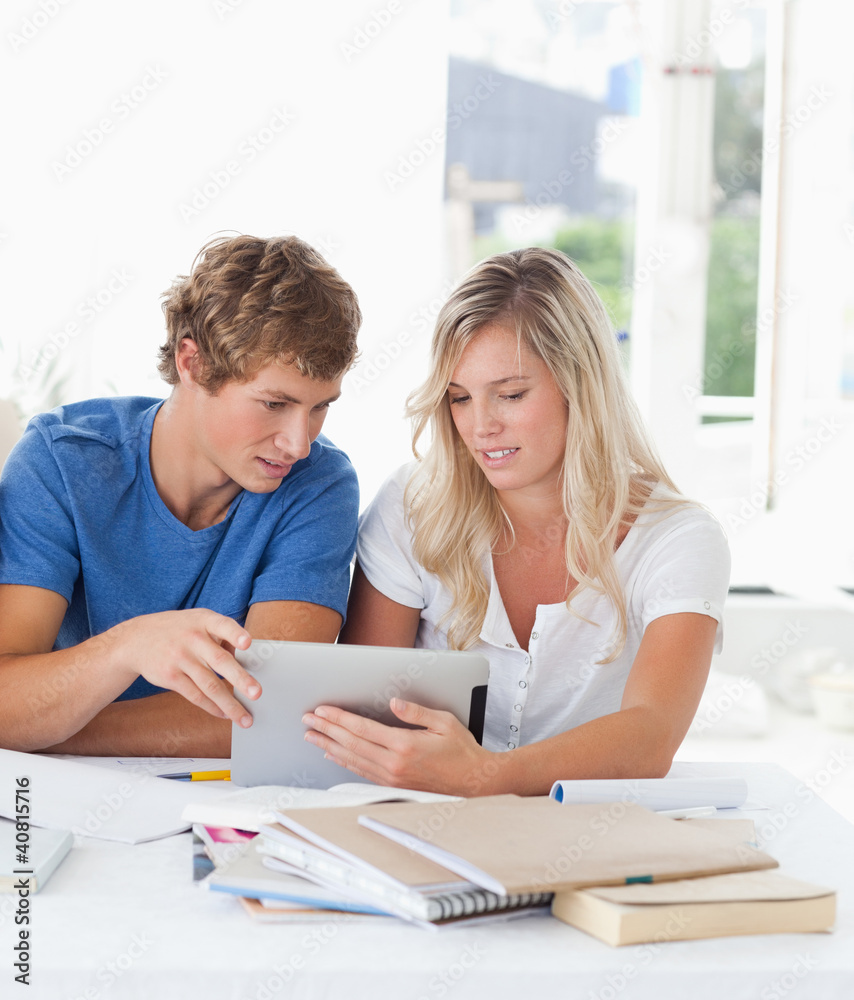 A couple look at a tablet together A couple look at a tablet together
