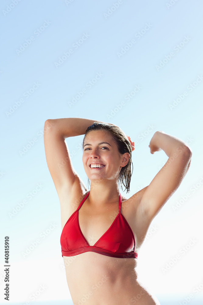 Smiling woman in bikini stretching Smiling woman in bikini stretching