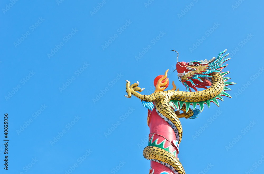 chinese dragon wrap on pole with red ball in blue sky chinese dragon wrap on pole with red ball in blue sky