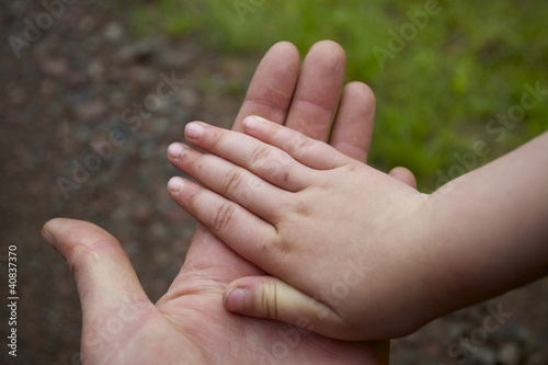 Hände von Vater und Kind übereinander