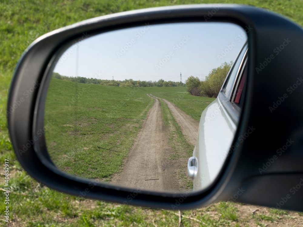 Rear view on a car mirror, road to hill