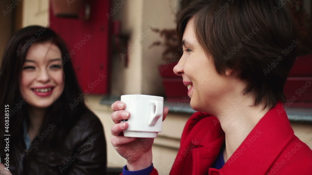 Female friends chatting and drinking coffee in outdoor cafe Female friends chatting and drinking coffee in outdoor cafe