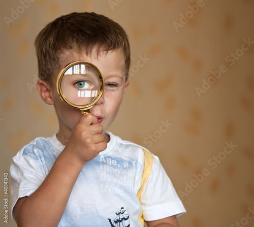 Curious boy with magnifying glass photo