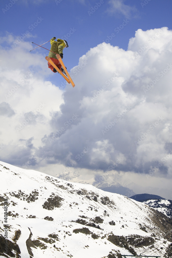 flying skier on mountains, in cloudy sky