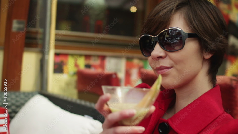 Happy young woman drinking cocktail in bar, steadicam shot Happy young woman drinking cocktail in bar, steadicam shot