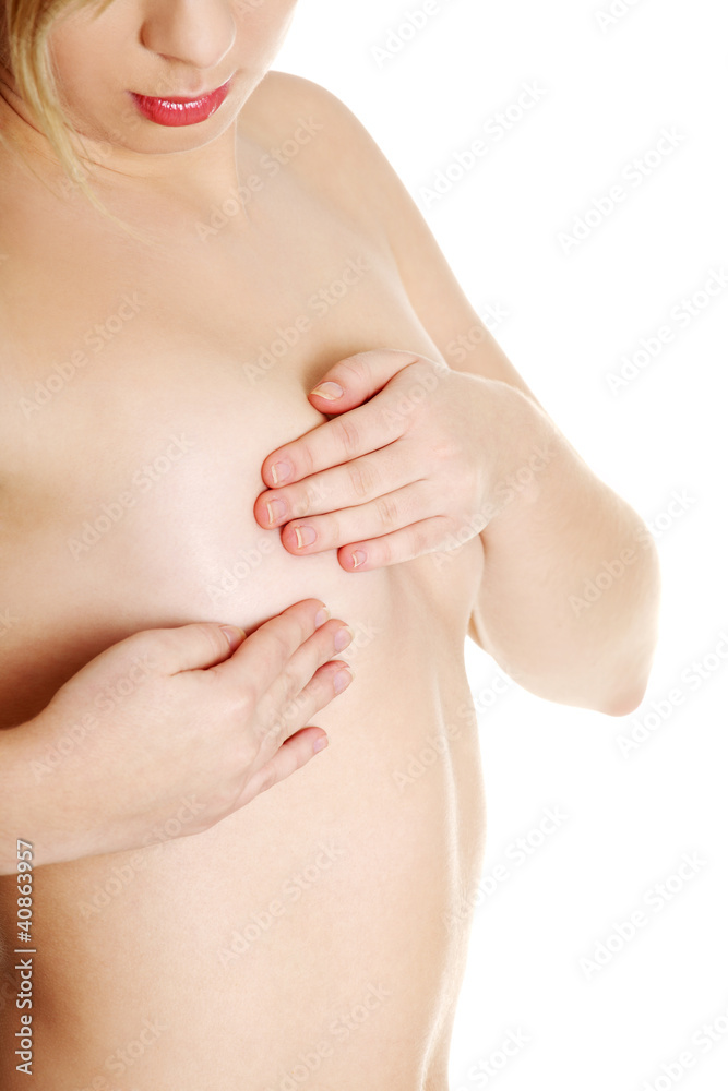 Young Caucasian adult woman examining her breast for lumps or si Young Caucasian adult woman examining her breast for lumps or si
