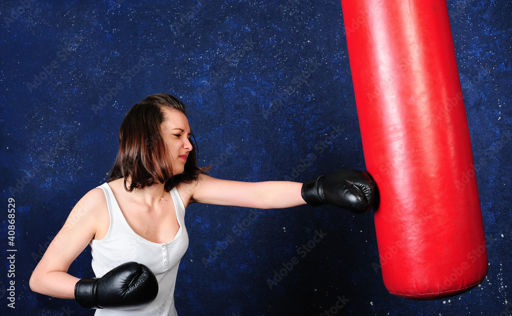 Young girl boxing a punchbag with all her efforts