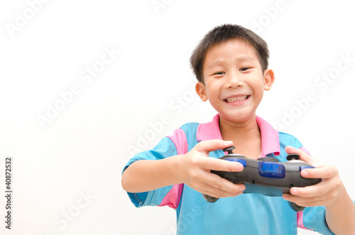 Photo of Asian boy with joystick playing computer game