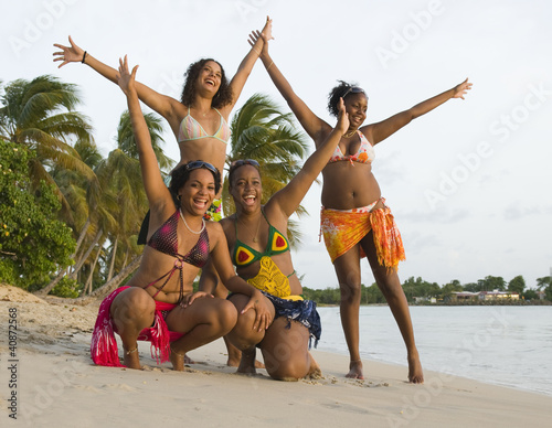 4 jeunes filles sur la plage les bras en l'air