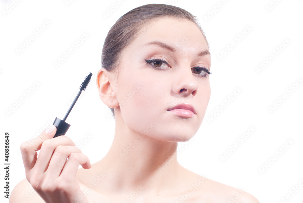 Young woman applying mascara
