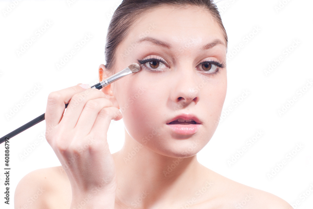 Woman applying eye shadow isolated on white Woman applying eye shadow isolated on white