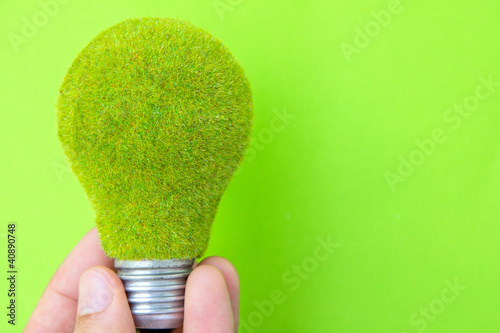 Photos light blub in hand with green background, eco energy concept