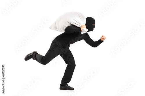 Thief carrying a bag and running away photo